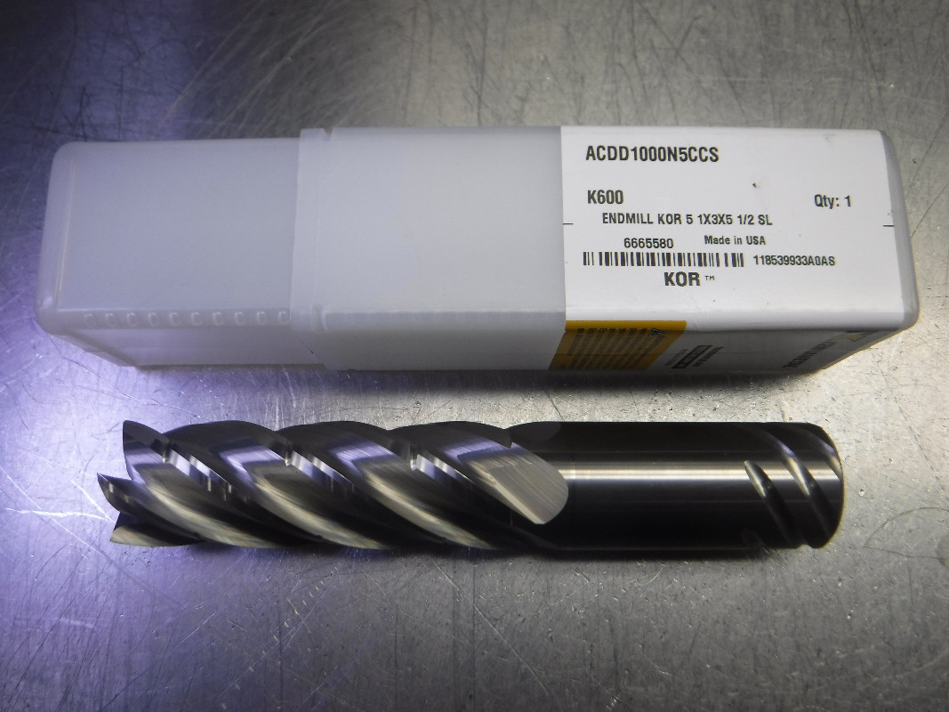 A one inch five-flute solid carbide end mill next to its Kennametal box, an example of the used and surplus end mills we sell